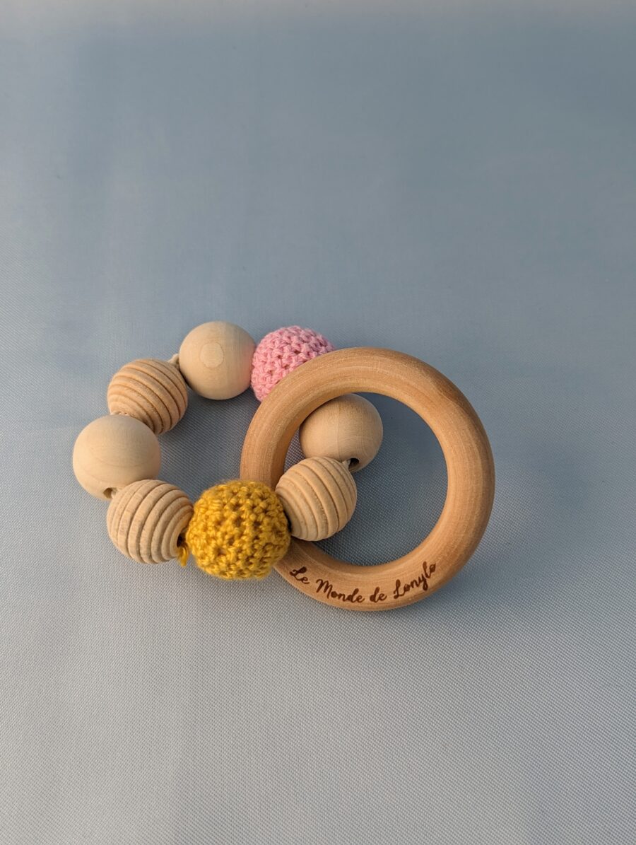 Hochet bébé en bois avec des perles en laines jaune et rose pour soulager les poussées dentaires
