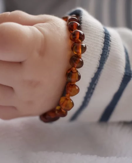 Bébé qui porte un bracelet d'ambre pour soulager les poussées dentaires