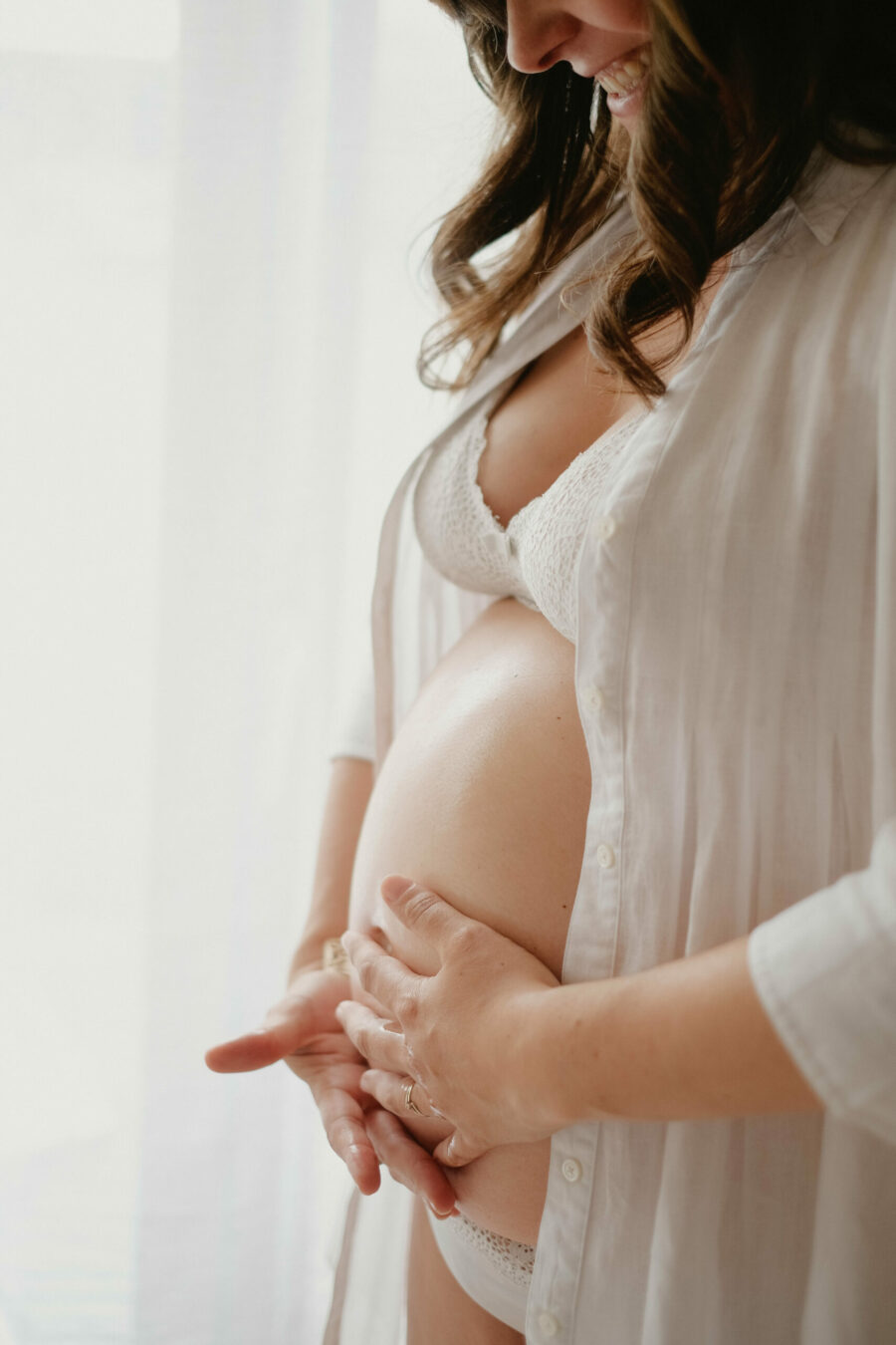 Femme enceinte qui applique de l'huile anti vergeture sur son ventre