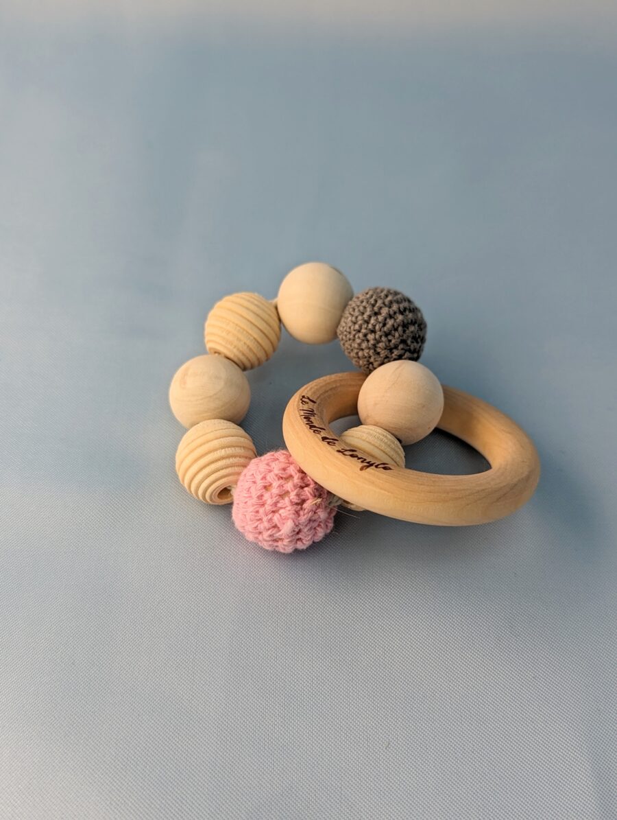 Hochet bébé en bois avec des perles en laines rose et grise pour soulager les poussées dentaires