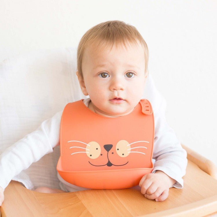 Bébé avec un bavoir en silicone orange motif chat