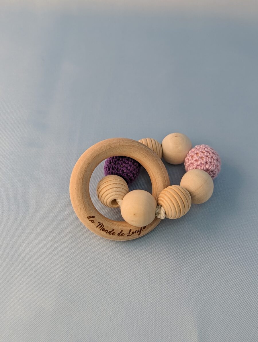 Hochet bébé en bois avec des perles en laines violette et rose pour soulager les poussées dentaires