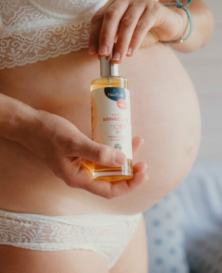 Femme enceinte qui pose avec l'huile anti vergeture
