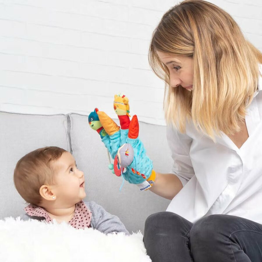 Maman qui joue avec son bébé avec une marionnette gant pour le stimuler
