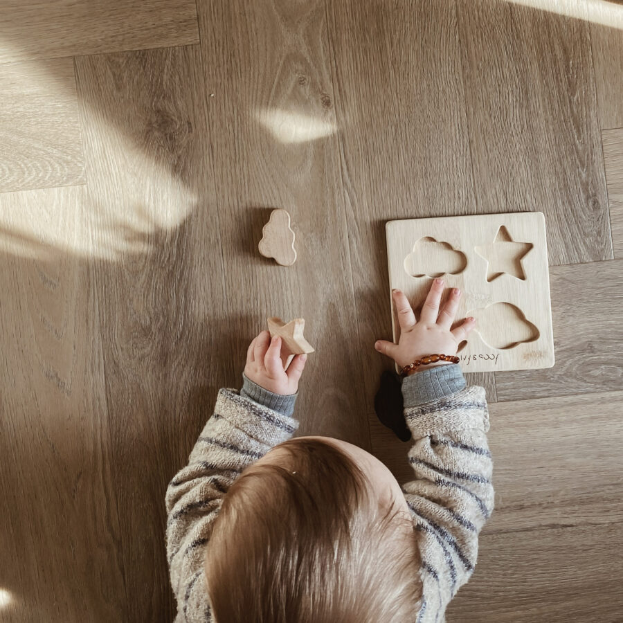 Bébé qui fait un puzzle en bois fabriqué à la main