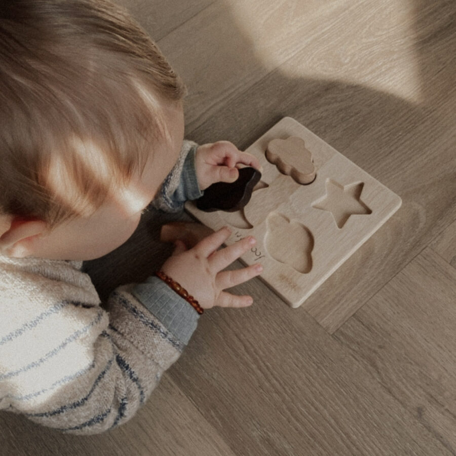 Bébé qui fait un puzzle en bois fabriqué à la main
