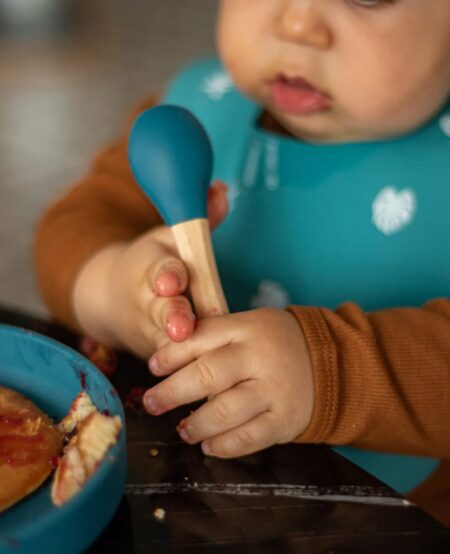 Bébé qui mange avec une cuillère