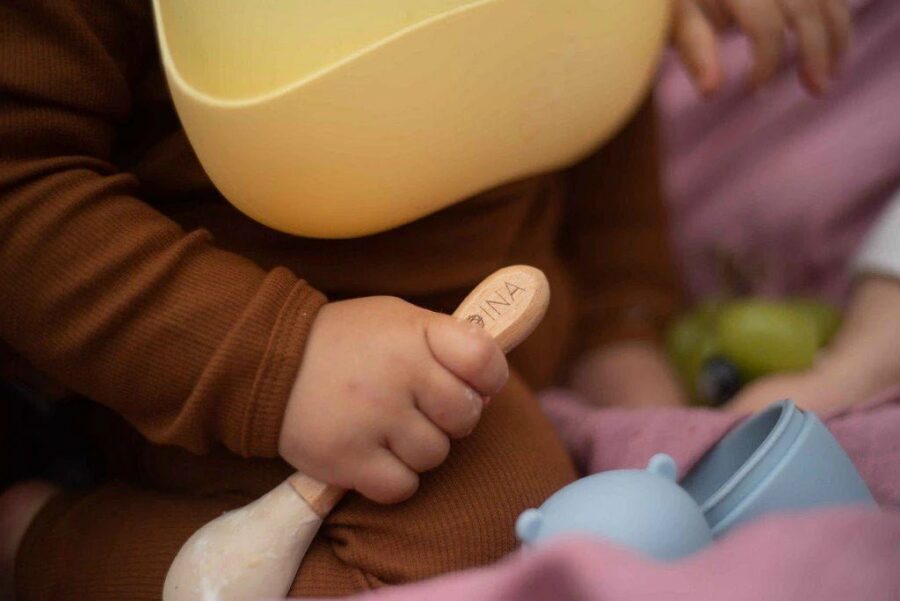 Bébé qui tient une cuillère pour le repas