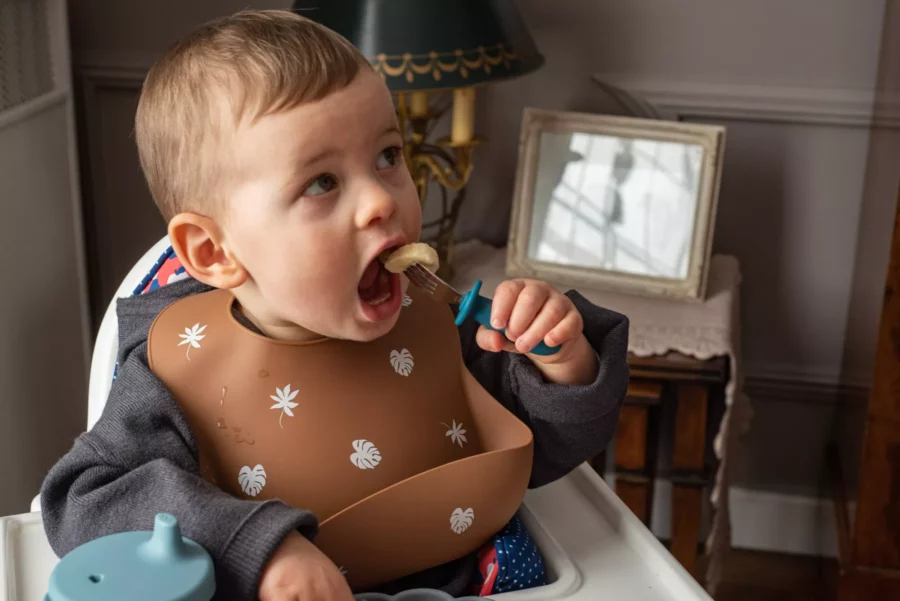 Bébé qui mange avec une fourchette métal