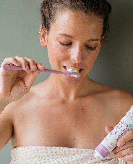 Femme enceinte qui se brosse les dents avec le dentifrice omum bio