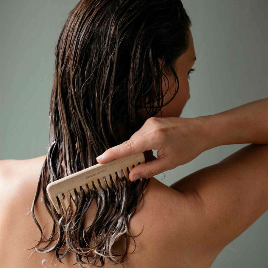 Femme enceinte qui se peigne les cheveux pendant que le soin pose l'après shampoing bio