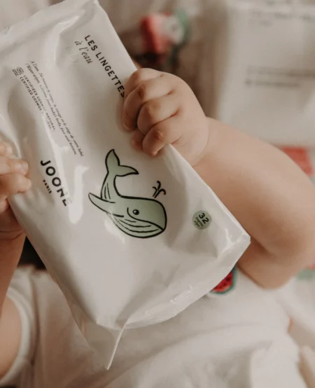 Bébé qui tient un paquet de lingette bio