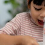 Petite fille qui fait un lavage de nez avec du serum physiologique fabriqué