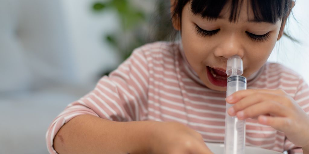 Petite fille qui fait un lavage de nez avec du serum physiologique fabriqué