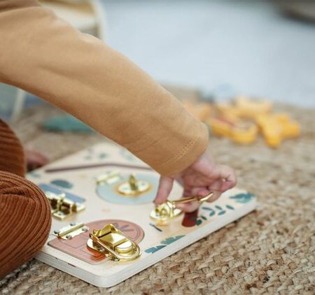 Moment d'éveil : enfant explorant la planche Montessori avec serrures