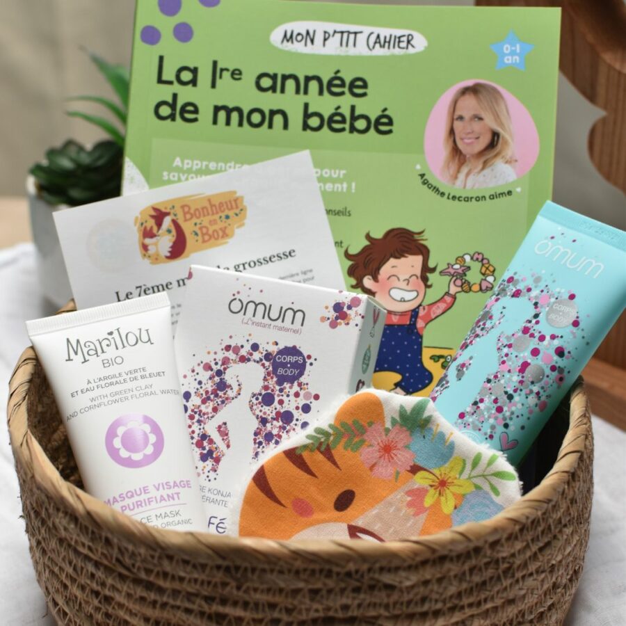 Vue d'ensemble d'une box future maman pour le 7ème mois de grossesse, comprenant un masque visage bio, une éponge konjac, un gel bio pour les jambes lourdes, une lingette lavable faite à la main, un livre sur la première année de bébé et un flyer sur le déroulement de la grossesse.