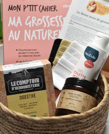 Vue d'ensemble d'une box future maman pour le 3ème mois de grossesse, comprenant une tisane digestive bio, des rallonges soutien gorge pour la poitrine qui prend du volume, un gel intime bio, un baume bio et un livre sur la grossesse au naturel.